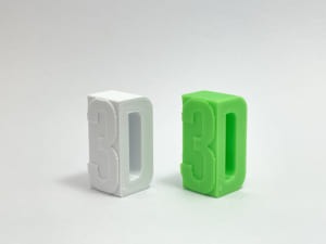3Dプリントされたプラスチック。直方体のような形で左の側面には3の文字、右の側面から見るとDの文字の形をしているので、斜めから見ると3Dと読める
